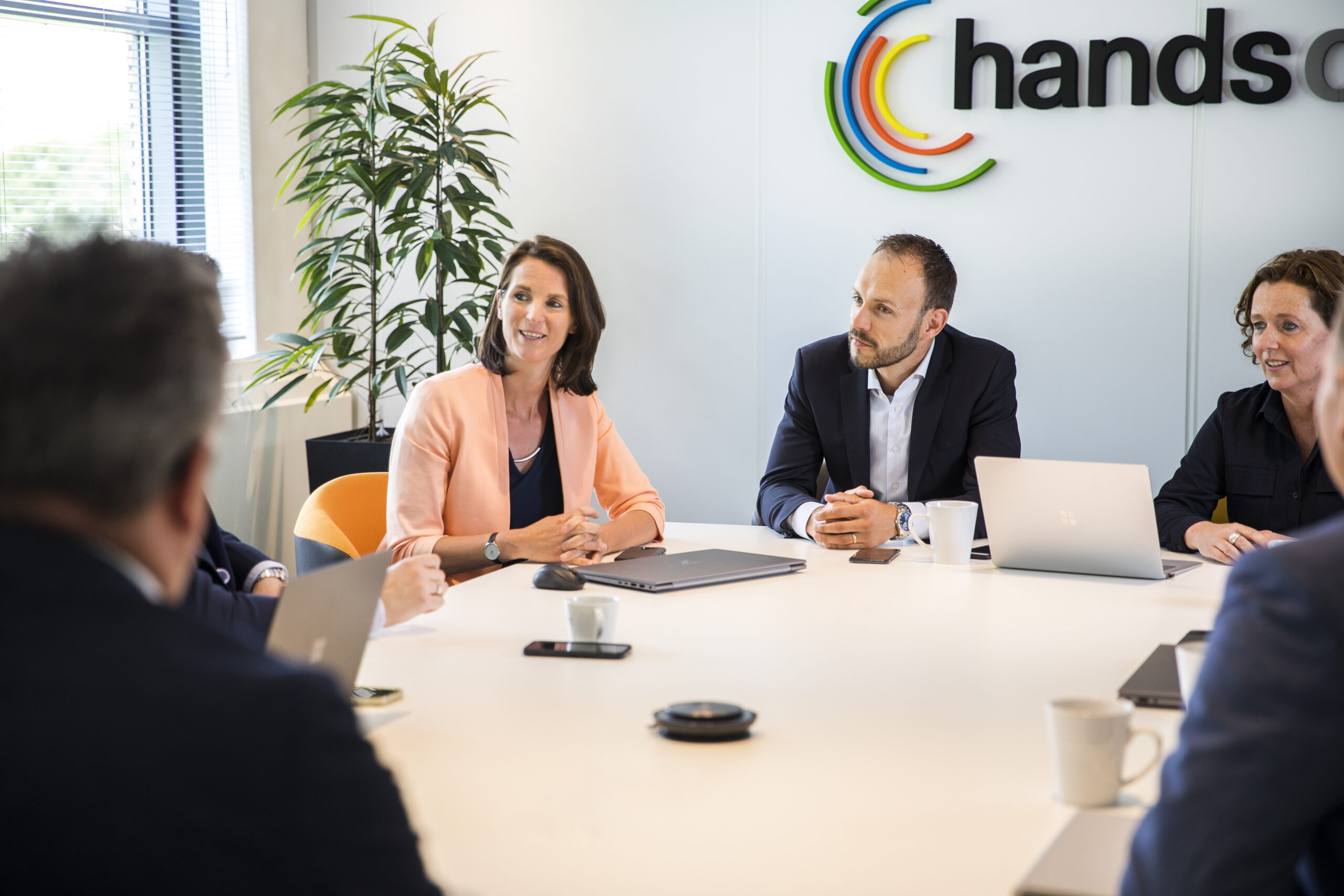 Collega’s van Hands on ICT in gesprek aan een vergadertafel